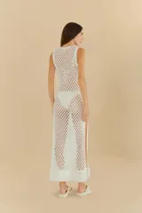 Vestido largo de crochet calado color blanco, sin mangas y con cuello redondo. Ideal para usar sobre traje de baño.