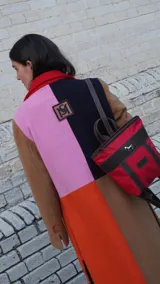 Mochila pequeña color borgoña con detalles en cuero marrón, asa de mano y correas ajustables.