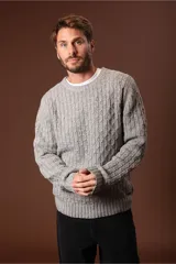 Sweater verde oliva de punto trenzado con cuello redondo y mangas largas.