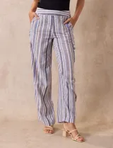 Pantalón de lino a rayas verticales en tonos beige, azul y blanco. Tiene pretina elastizada, bolsillos inclinados delanteros y bolsillo lateral tipo cargo.