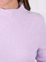 Polera lavanda de cuello alto y manga larga con textura.