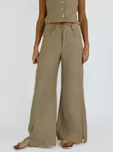 Pantalón de tiro alto color ladrillo, de corte palazzo con aberturas laterales en el ruedo y terminación desflecada.