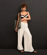 Pantalón de playa de lino y viscosa color blanco, con rayas laterales a contratono, cintura elastizada y lazo ajustable.
