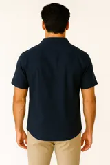 Camisa de lino color marrón, de corte holgado, con cuello tipo solapa, manga corta y cierre frontal con botones.