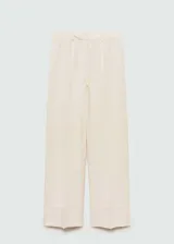 Pantalón de vestir color crema, de corte recto y largo, con pinzas delanteras, bolsillos laterales y trabillas.