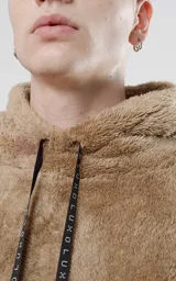 Hoodie color beige de piel sintética de corderito, corte oversize, con capucha ajustable con cordón y bolsillo canguro.