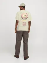 Camiseta color crema de manga corta y cuello redondo con calce holgado. Estampa en la espalda con print de goma de tacto suave.