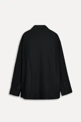 Camisa negra oversize de popelina de algodón, con cuello solapa, manga larga con puños abotonados, pinzas en la espalda y cierre frontal con botones.