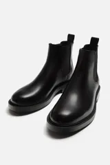 Bota Chelsea marrón de cuero, con elásticos laterales y tirador trasero. Suela negra con ligero tacón.