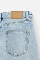 Pantalón de jean celeste de corte recto, con cinco bolsillos, efecto lavado y cierre frontal con botones.