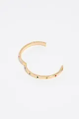 Pulsera rígida de aleación metálica plateada con cristales incrustados y detalles grabados. Cuenta con un cierre de bisagra lateral para mayor seguridad.