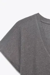 Camiseta color crudo de corte recto, escote en V, manga corta y confeccionada en tejido de algodón y lino.