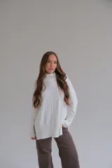 Sweater blanco de corte recto con cuello alto y aberturas laterales.