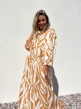 Vestido largo tipo túnica con estampado de cebra en tonos beige y crudo, con cuello en V y mangas 3/4.