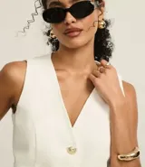 Chaleco color crudo confeccionado en sarga con botones delanteros de escudo y pences. Este producto posee algodón certificado BCI en su composición, siendo ambientalmente más sostenible.