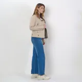 Campera color taupe de cuero sintético con cierre frontal, cuatro bolsillos externos con herrajes plateados y ajuste regular.