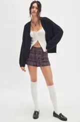 Cárdigan negro de silueta oversized, confeccionado en hilo de algodón suave con terminaciones acanaladas, escote en V, hombros caídos y mangas largas amplias.