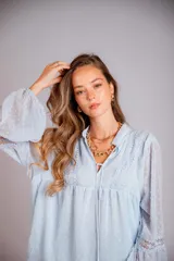 Camisa celeste de plumetí con cuello mao, mangas largas abullonadas con puños elásticos y cordón en el escote.