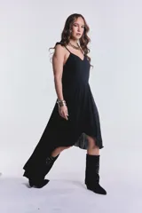 Vestido negro largo irregular con breteles finos y escote en V.