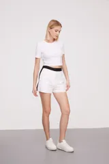 Short de lino blanco con cintura alta negra y corte recto.