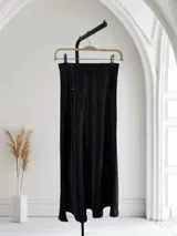 Pollera larga de satén color blanco con pequeños brillos.