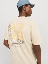 Camiseta de manga corta color crema, con cuello redondo y calce relajado. Presenta un pequeño logo de Jack & Jones estampado en el pecho y un estampado grande en la espalda.