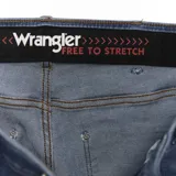 Jean de hombre Wrangler modelo River, de corte slim fit, color azul denim con lavado claro y detalles de desgaste.