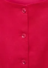 Vestido corto color fucsia, sin mangas, con cuello redondo y cierre frontal con botones. Presenta dos bolsillos laterales de ribete y forro interior.