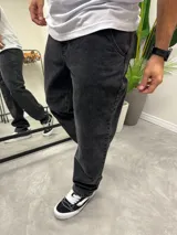 Pantalón de jean negro con efecto gastado, corte amplio y tiro medio.