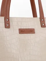 Cartera tote Hush Puppies modelo Stella, color azul marino con textura símil cocodrilo. Tiene doble asa de hombro, cierre superior y correa larga extraíble. Interior forrado con bolsillos organizadores.