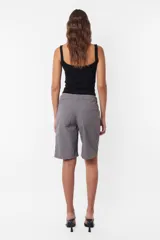 Bermuda gris de largo jort, tiro medio, con cordón con punteras y tancas metálicas, acceso con cierre y botón, pasacintos en cintura, bolsillos laterales delanteros y dos bolsillos clásicos en espalda. Incluye llavero TW.