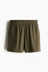 Short verde militar de lino con cintura elastizada y bolsillos laterales.
