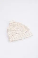 Gorro de lana color beige con textura acanalada y pompón en la parte superior.