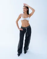 Pantalón deportivo negro con recortes en gris y vivos blancos. Tiro medio, corte holgado, cintura elastizada y cierre en los tobillos.