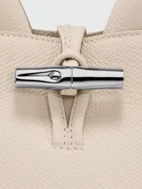 Bolso Longchamp modelo Le Roseau XS, color beige, con doble asa corta y correa larga extraíble.