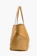 Bolso tipo shopper grande color marrón claro, confeccionado en cuero. Tiene doble asa de hombro y detalle de pespuntes en contraste. Incluye cierre con tiras y botón, y cartera con bolsillo extraíble.