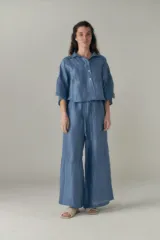 Conjunto de camisa y pantalón celeste con textura arrugada. La camisa es crop con cuello clásico y mangas cortas. El pantalón es de corte ancho con cintura elastizada y cordón ajustable.
