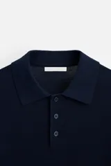 Polo de hombre color gris oscuro, de punto ligero tejido en hilatura con mezcla de seda y algodón. Tiene cuello solapa con cierre frontal de botonadura, manga larga y acabados en rib.