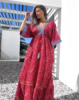 Vestido largo tipo túnica con estampado paisley en tonos rojos y detalles bordados en azul en escote y mangas.