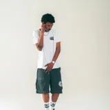 Bermuda negra de nylon liviano con cintura elastizada, cordón ajustable, bolsillos laterales y bolsillos cargo con micro logo en la parte trasera.