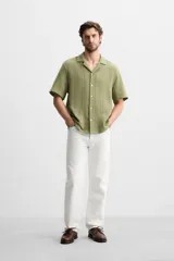 Camisa verde oliva de manga corta con cuello bowling, corte relaxed fit y cierre frontal con botones.