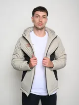Campera corta de abrigo Umbro Crafted Pro, color negro con paneles laterales en gris. Presenta capucha con cordón ajustable, cierre frontal completo y logo de la marca bordado en el pecho.