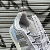 Championes Adidas NMD_V3 color gris con detalles plateados y suela blanca con tecnología Boost.