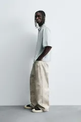 Pantalón de jean blanco, corte holgado y amplio en toda la pierna, tiro medio, tejido ligero, cinco bolsillos, efecto lavado y cierre frontal con cremallera y botón.