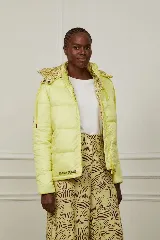 Campera puffer amarilla con estampado abstracto en color borgoña, con capucha y cierre frontal con botones a presión.