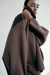 Sweater marrón de lana con cuello alto, corte oversize y mangas largas.