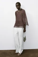 Top marrón con lunares blancos, cuello halter con fornitura dorada y bufanda integrada. Espalda descubierta y forro interior.