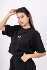 Remerón negro de corte holgado con mangas cortas y logo pequeño estampado en el pecho.