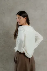 Remera negra de manga larga con costuras decorativas en color ocre en hombros y escote.