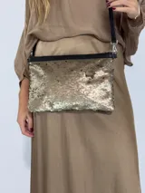 Cartera con superficie de lentejuelas de doble cara que cambian de color al tacto, con bordes de cuero.